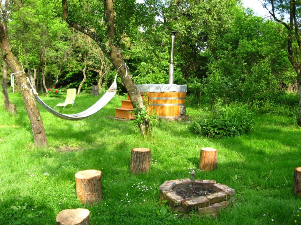un jardín con una hamaca en el césped con árboles en Vidéki Ház-Őrség, en Kerkafalva