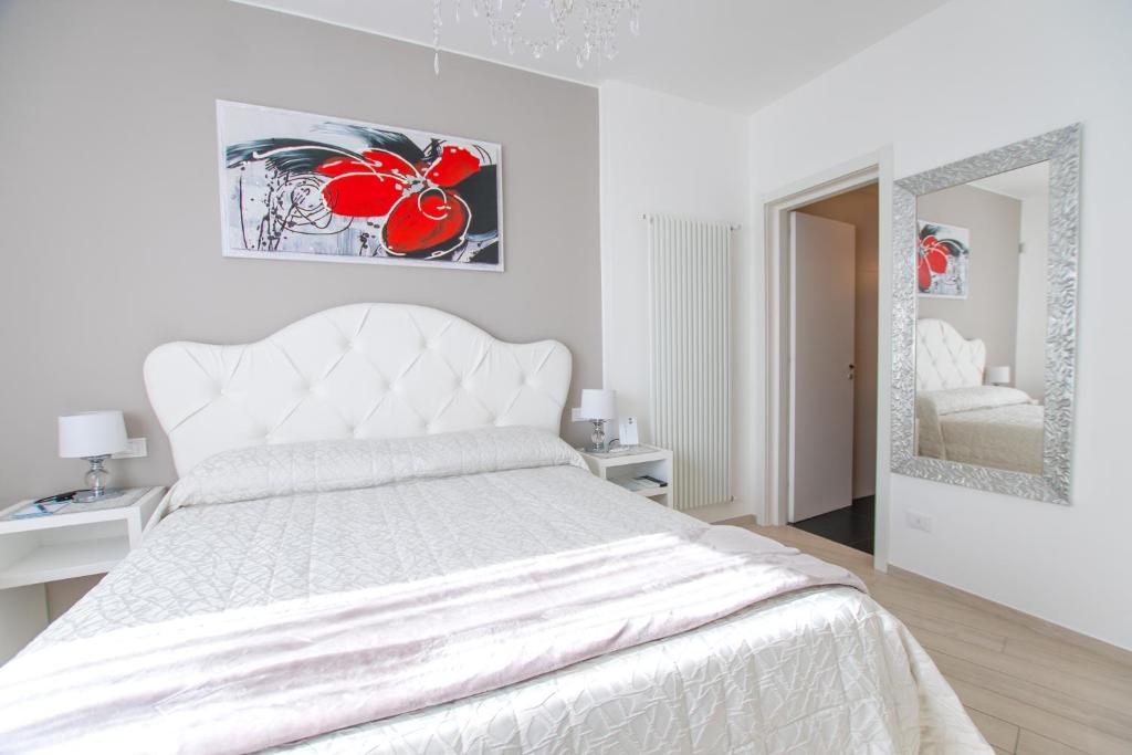 a white bedroom with a white bed and a mirror at Bellariva Monopoli B&B e Relax in Monopoli