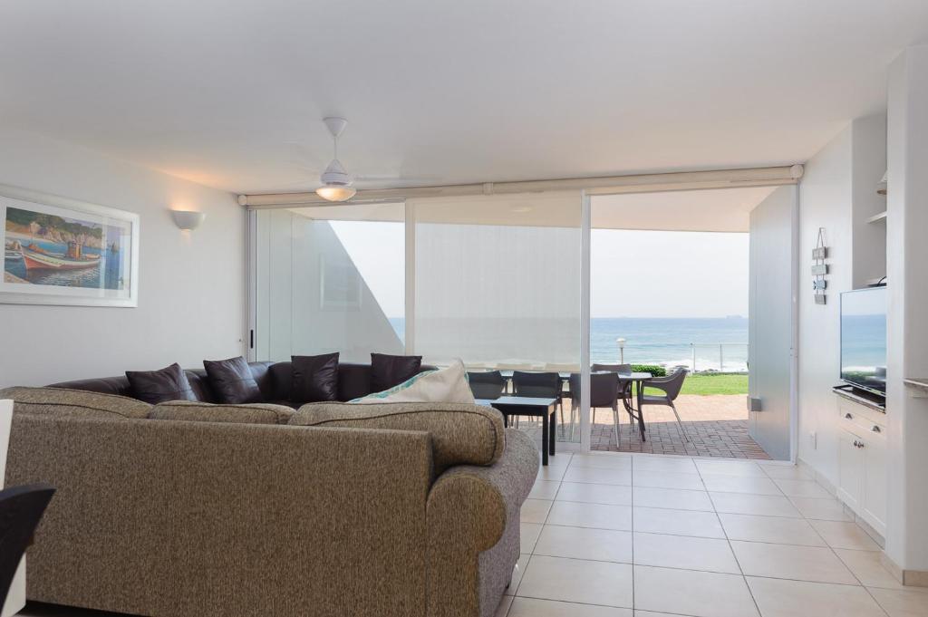 a living room with a couch and a dining room at Suntrap 6 - FAMILY ONLY in Ballito