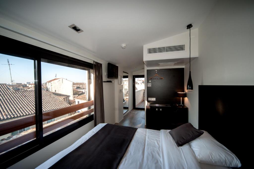 1 dormitorio con cama y ventana grande en Central Hotel en Nimes