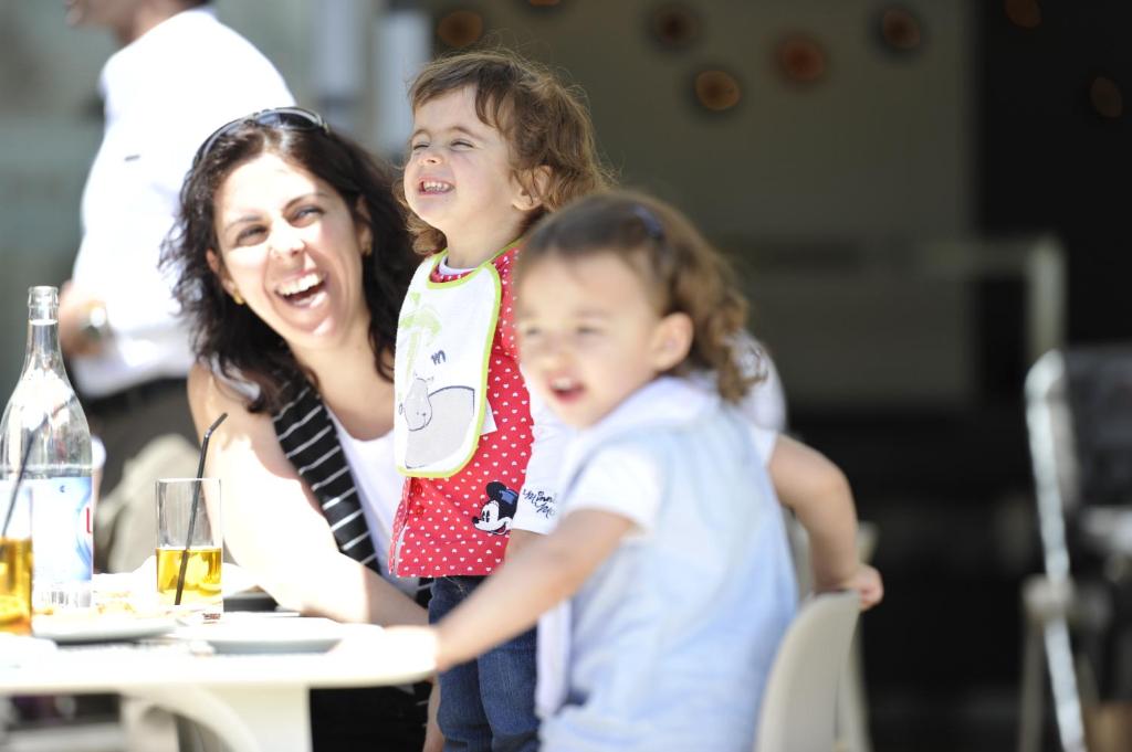 a woman and two children sitting at a table at Martinhal Sagres Beach Family Resort Hotel in Sagres