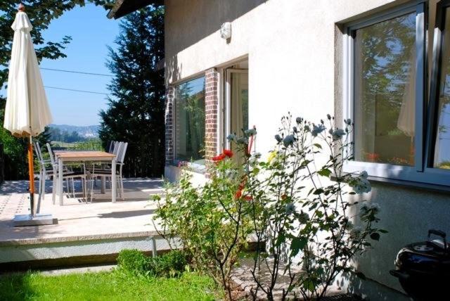 una casa con una mesa y una sombrilla en un patio en Apartment Sternentor en Engerwitzdorf