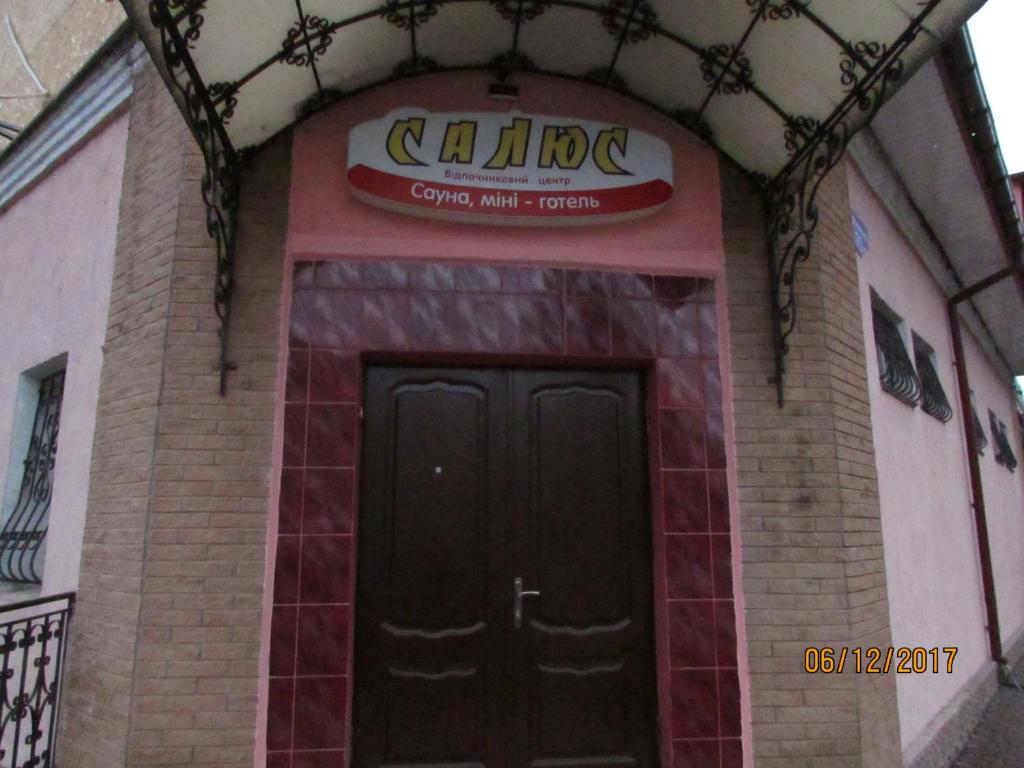 una entrada a un edificio con una señal sobre una puerta en Salus, en Khmelʼnytsʼkyy