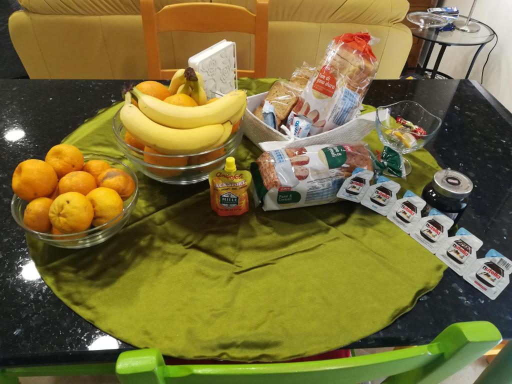 uma mesa com bananas laranjas e outros frutos em Augusta Isola Appartamento in Pieno Centro em Augusta