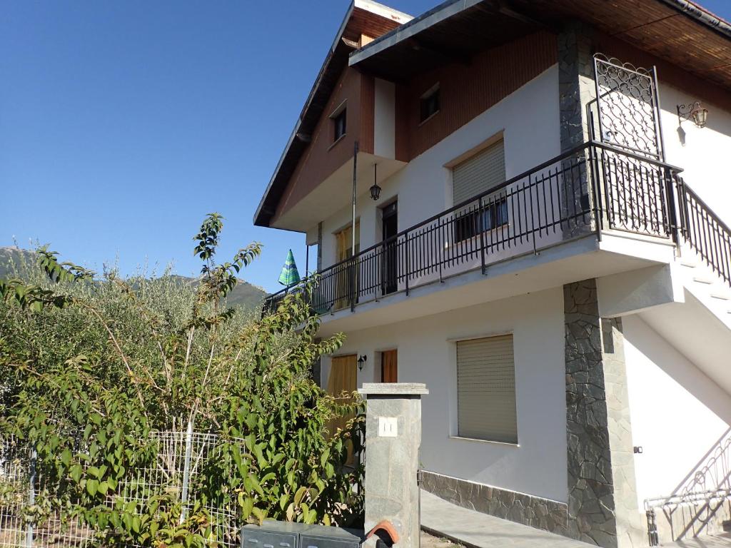 ein weißes Gebäude mit Balkon darüber in der Unterkunft Casetta tra gli Ulivi vicina al Mare in Giustenice