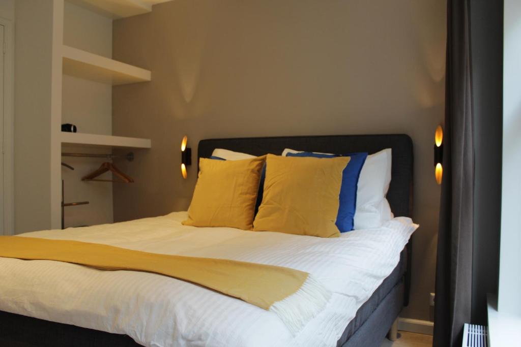 um quarto com uma cama com almofadas amarelas e azuis em Rust B&B em Amsterdã