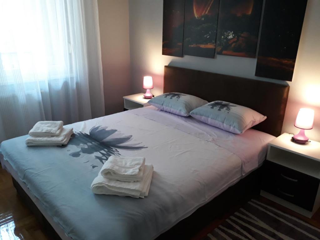 a bedroom with a large bed with towels on it at Apartment Azzuro 2 in Novi Sad