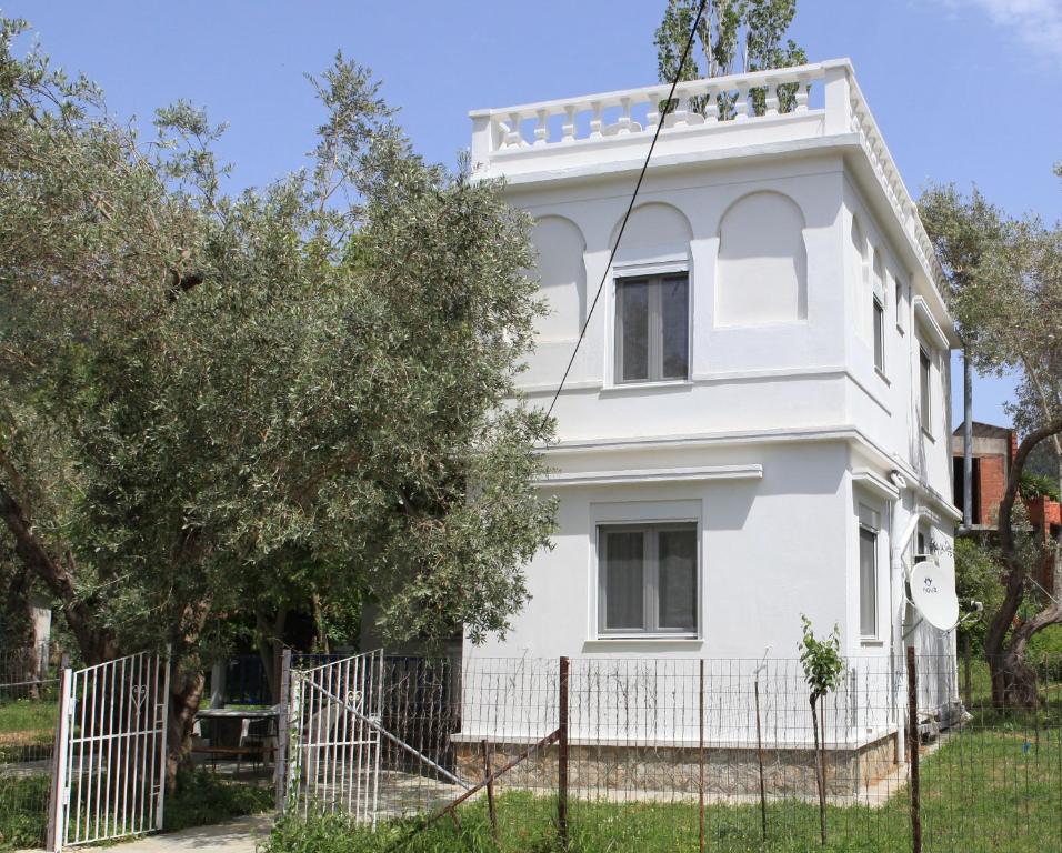 una casa blanca con una valla delante en O Pyrgos Accommodations en Panormos Skopelos