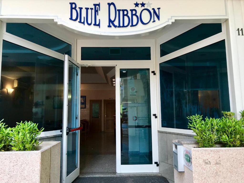 un edificio con un cartel de cinta azul sobre la puerta en Hotel Blue Ribbon en Rímini