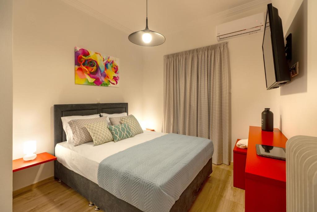 a bedroom with a bed and a flat screen tv at Koukaki Central Apartment in Athens