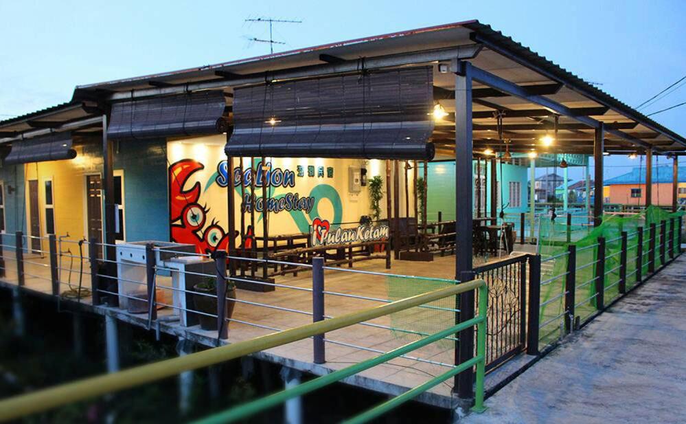 a train station with a building with graffiti on it at Sea Lion Pulau Ketam Bungalow Homestay in Bagan Teochew