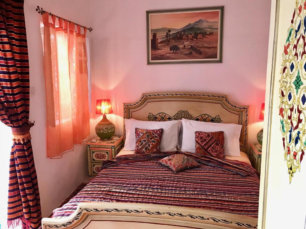 a bedroom with a bed with pink walls at Riad DAR BARBI in Marrakesh