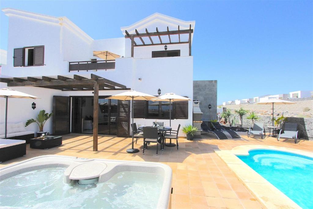 a villa with a swimming pool and a house at Villa Emma Playa Blanca in Playa Blanca