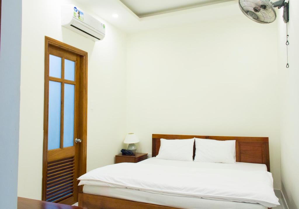 a bedroom with a bed and a window at Nhà nghỉ Linh Quân in Vung Tau