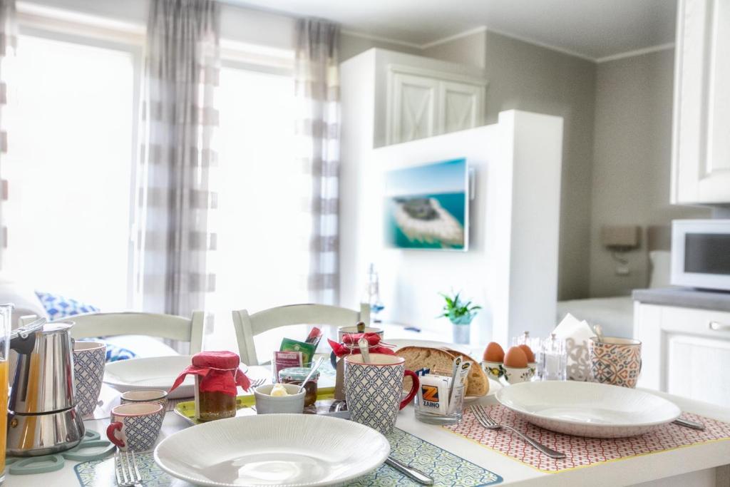 una cocina con una mesa con platos. en San Lorenzo Apartments, en Sirmione