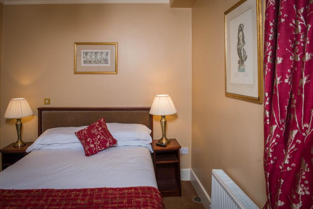 a bedroom with a bed with red pillows on it at Gabriel House Guesthouse in Cork