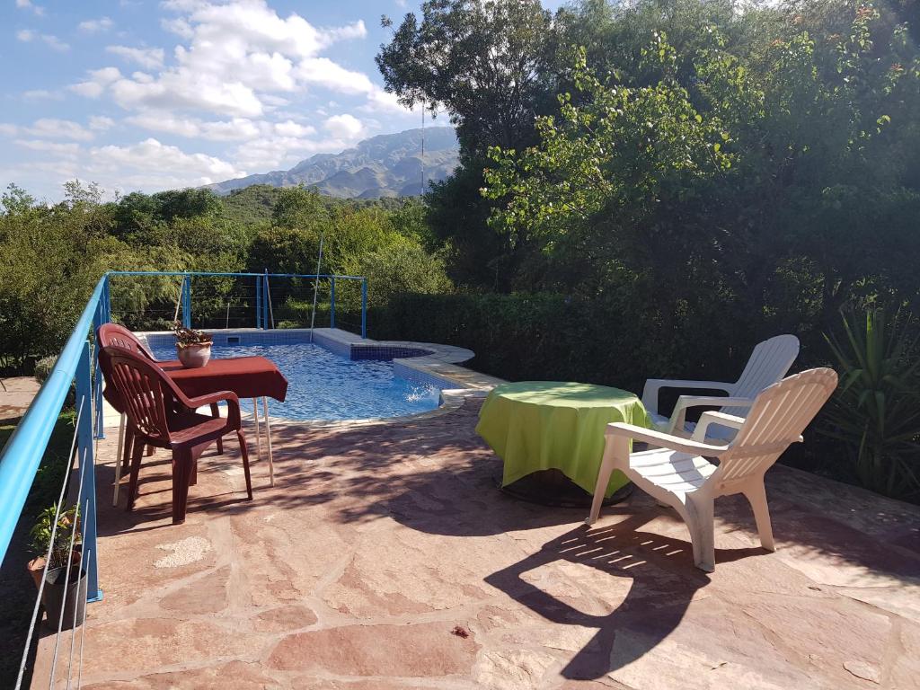 un patio con sillas y una mesa junto a la piscina en Cabañas Wayramuyu en Merlo