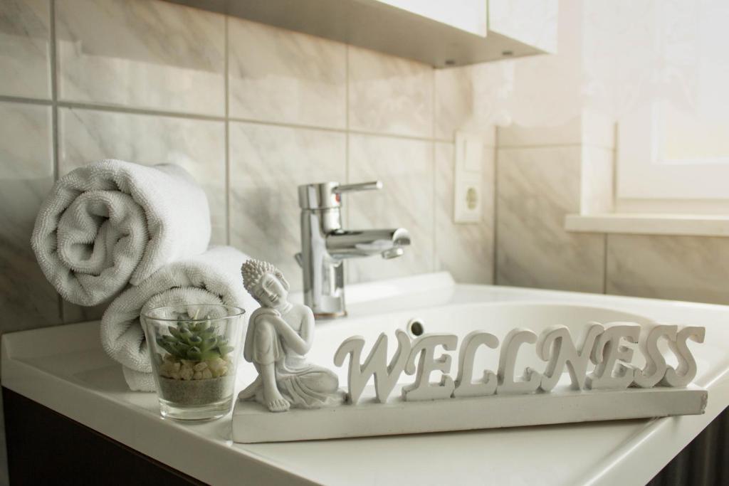 a bathroom sink with a sign that reads wellness at Bella Casa in Überlingen