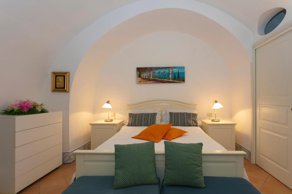 um quarto com uma cama branca e 2 candeeiros em Apartment Stella Maris em Capri