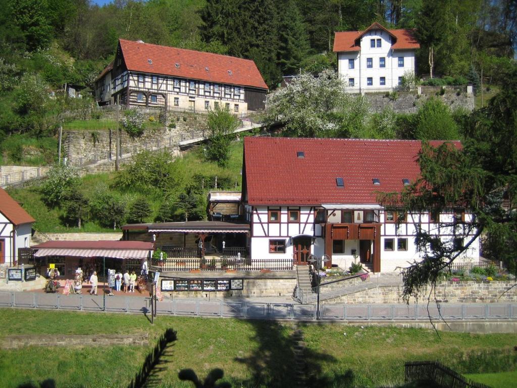 un edificio con techo rojo en una localidad en Ferienwohnung Am Grünbach en Kurort Rathen