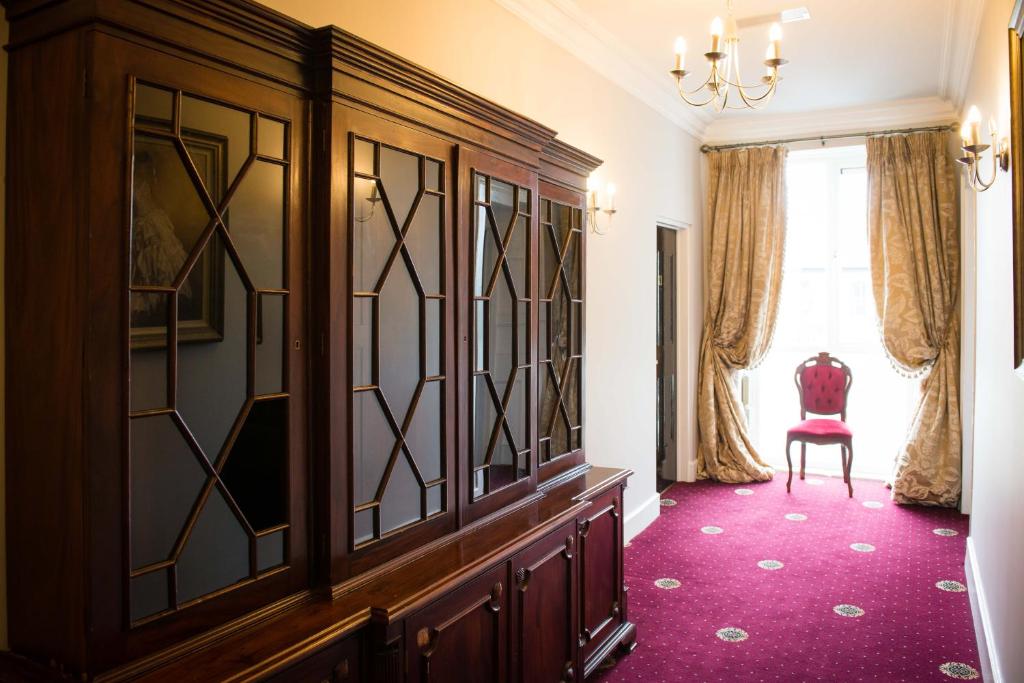 a room with a wooden cabinet and a red carpet at Gabriel House Guesthouse in Cork