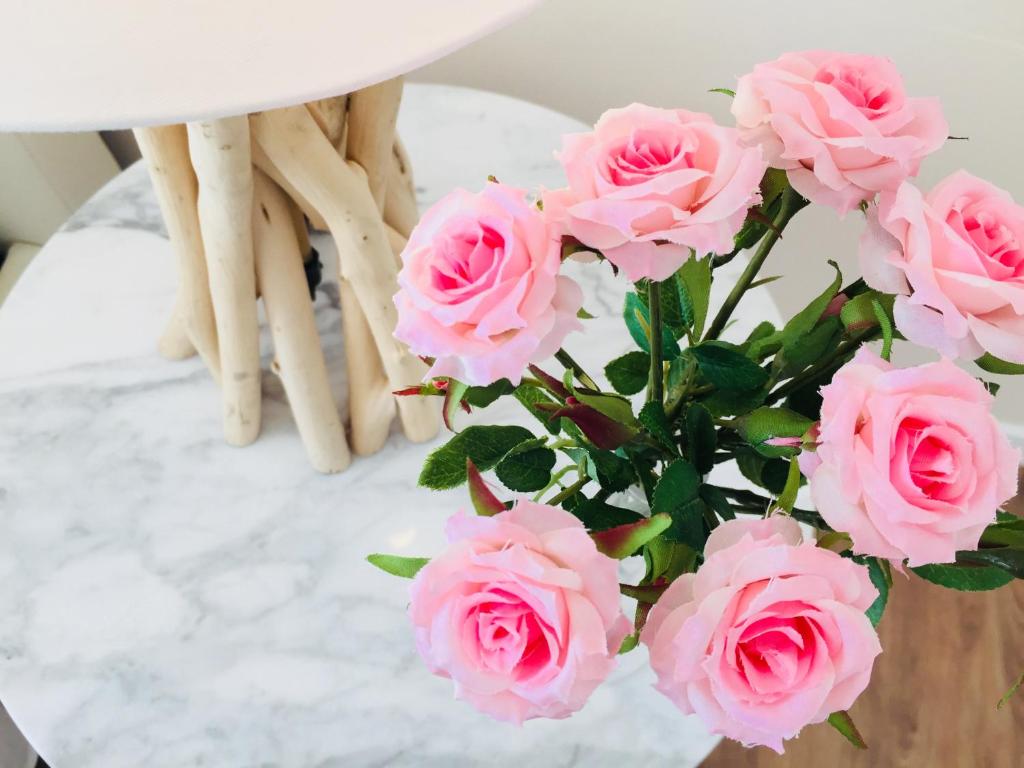un jarrón lleno de rosas rosas sobre una mesa en Flowers Sweet Rooms B&B, en Vasto