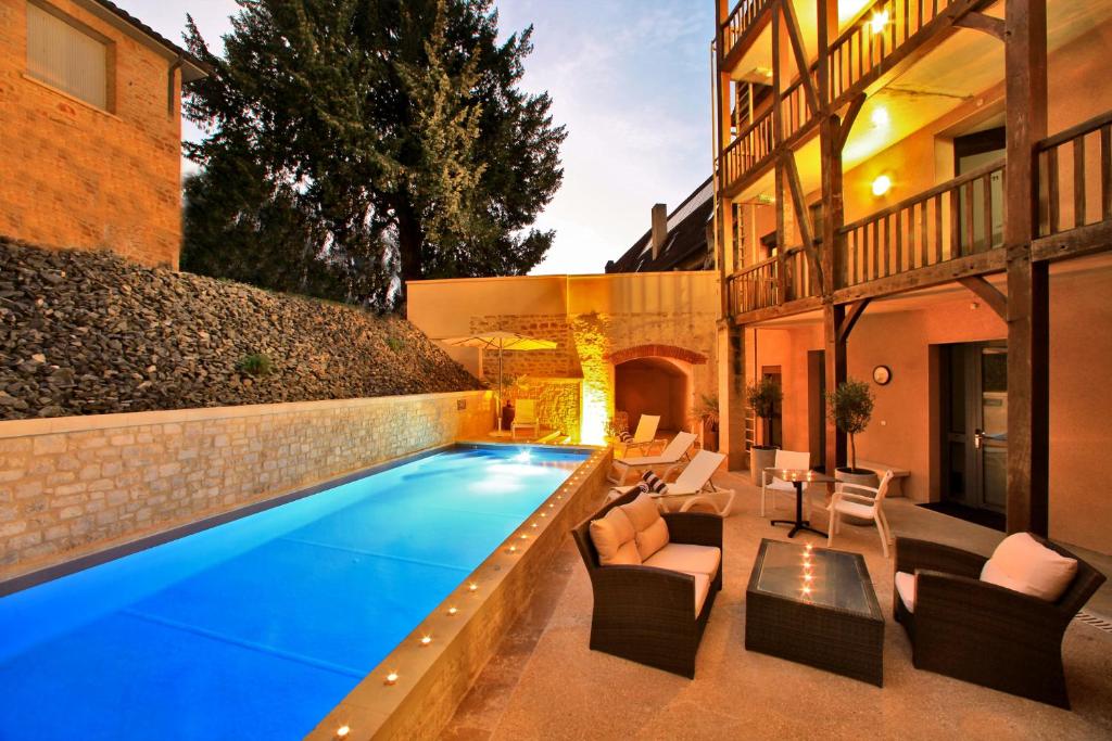 a swimming pool in the backyard of a house at Hotel de Compostelle in Sarlat-la-Canéda