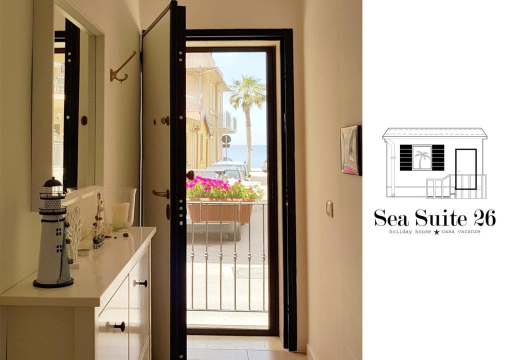 a bathroom with a door leading to a balcony at Sea Suite 26 in Scilla