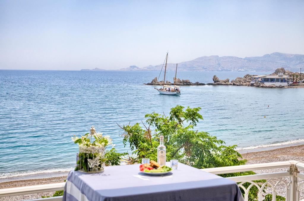 une table avec une assiette de nourriture et un bateau dans l'eau dans l'établissement Chara's Sea View House, à Haraki