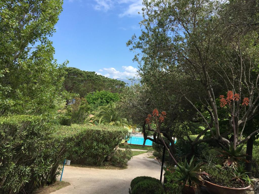 a garden with a swimming pool and trees at Résidence Fior di Rena in Saint-Florent