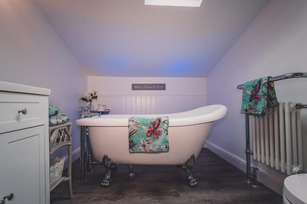 a bath tub in a bathroom with purple walls at 40 Kirkgate in Thirsk