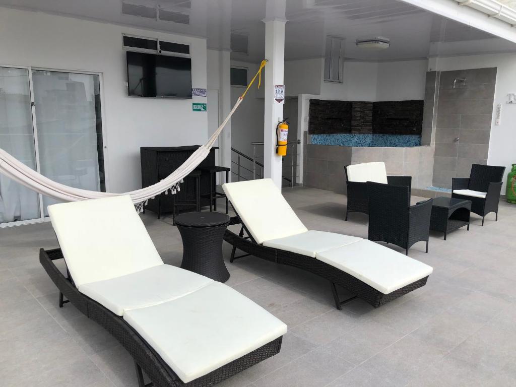eine Gruppe weißer Stühle und Tische in einem Zimmer in der Unterkunft Sashii Hostel & Boutique. in Ríohacha