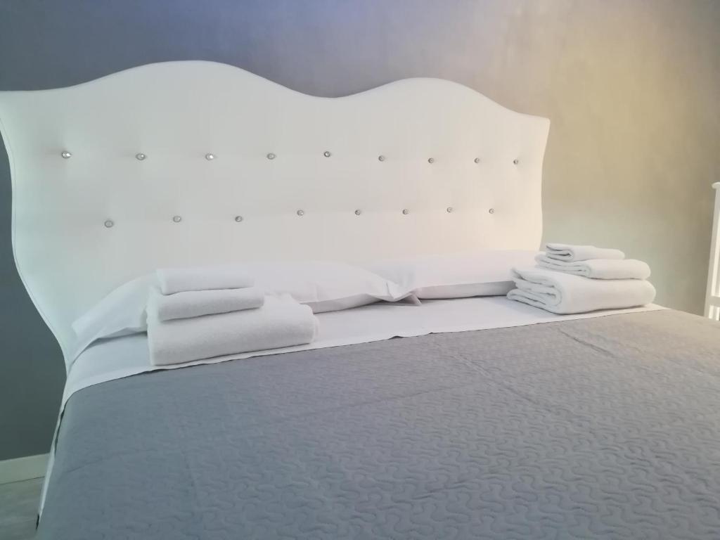 een wit bed met witte handdoeken erop bij Casa D'Amore in Napels