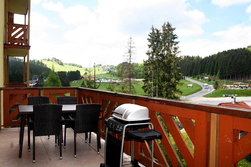 a balcony with a grill and a table and chairs at Apartmán Tatran Donovaly Deluxe in Donovaly