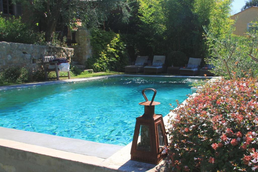 una pequeña piscina con una linterna al lado en Les Rosées, en Mougins