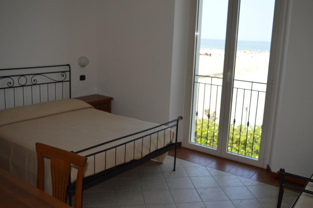 um quarto com uma cama e vista para a praia em Residenza Villa Margherita em Rimini