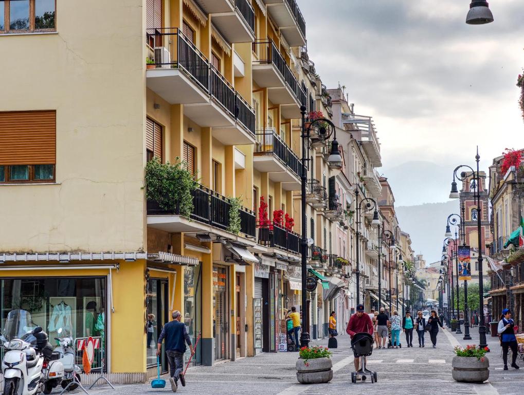 people walking down a street in a city with buildings at Dea Guest House in Sorrento
