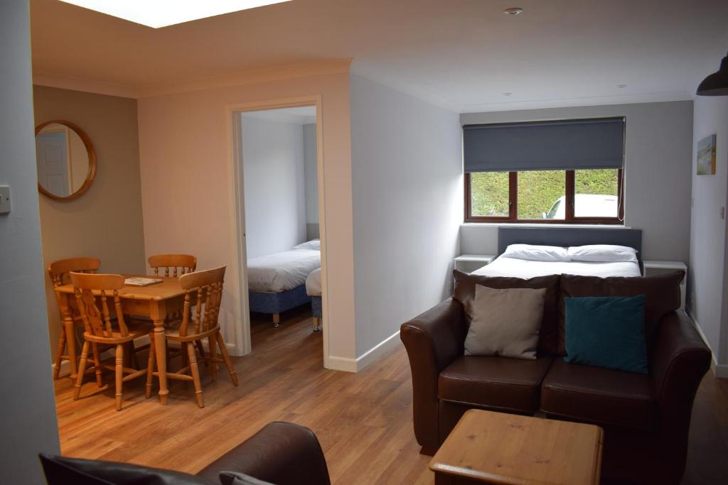 a living room with a couch and a bed and a table at Newlands Holidays in Bridport