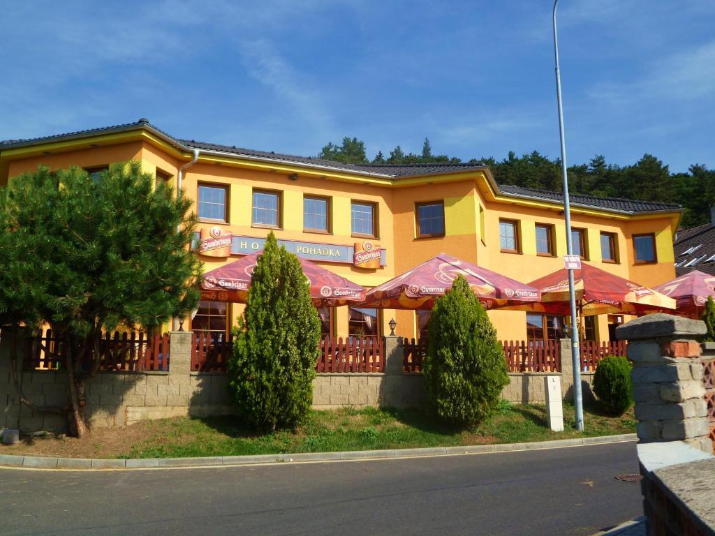 Hotel Pohádka في موست: مبنى اصفر مع مطعم على جانب الشارع