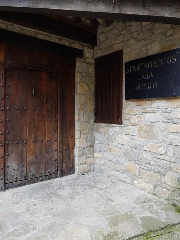 un ingresso a un edificio in pietra con porta in legno di Casa Simón a Roda de Isábena