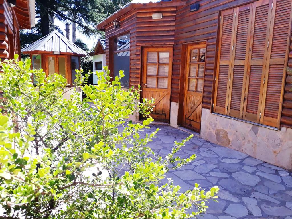 una casa con puertas de madera junto a un patio en Sierra Suites en Sierra de los Padres