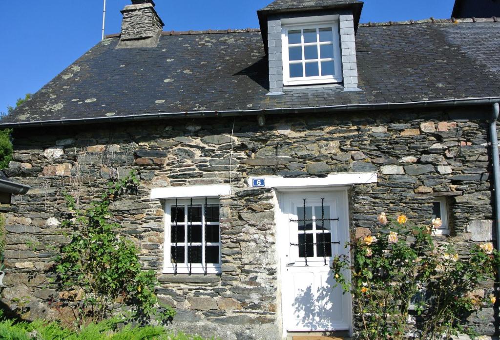 CaurelにあるCaurel Cottageの白いドアと窓のある古い石造りの家
