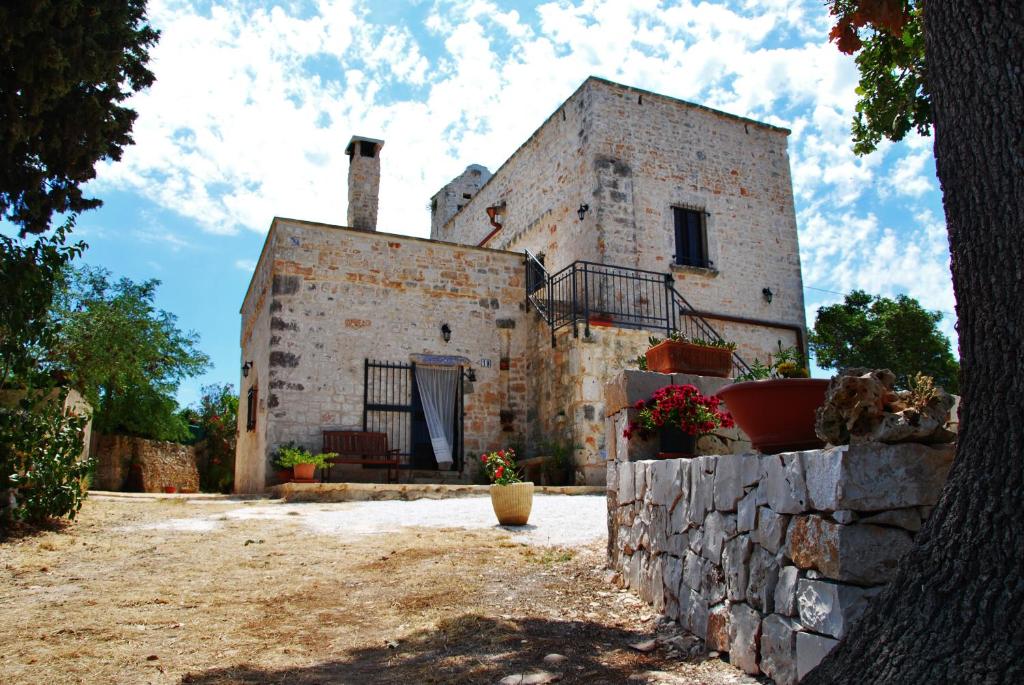 ein altes Gebäude mit einer Steinmauer davor in der Unterkunft Il Trullo E Il Fortino in Alberobello