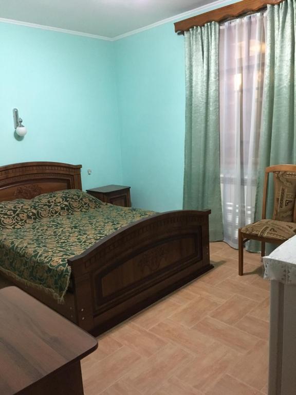 アドレルにあるLidiya Guest Houseのベッドルーム1室(ベッド1台、テーブル、椅子付)