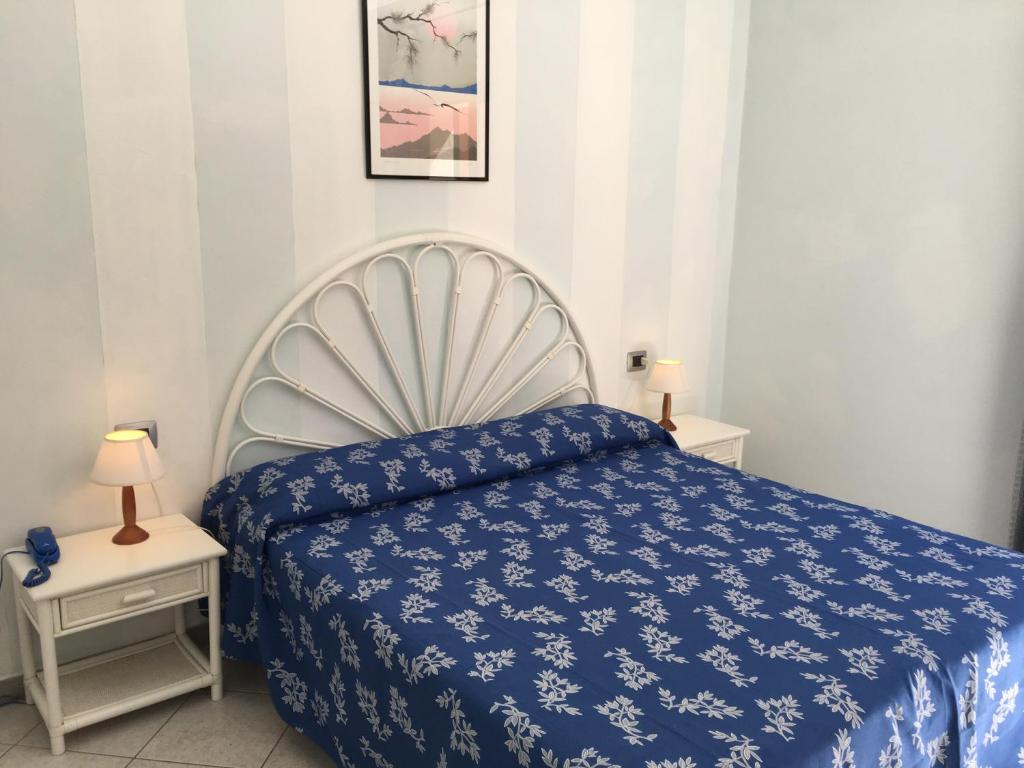 a bedroom with a blue bed and two night stands at Hotel Danila in Portoferraio