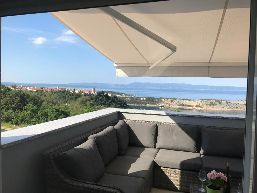 a couch on a balcony with a view of the ocean at Apartmenthaus Suskovic Insel Krk in Omišalj
