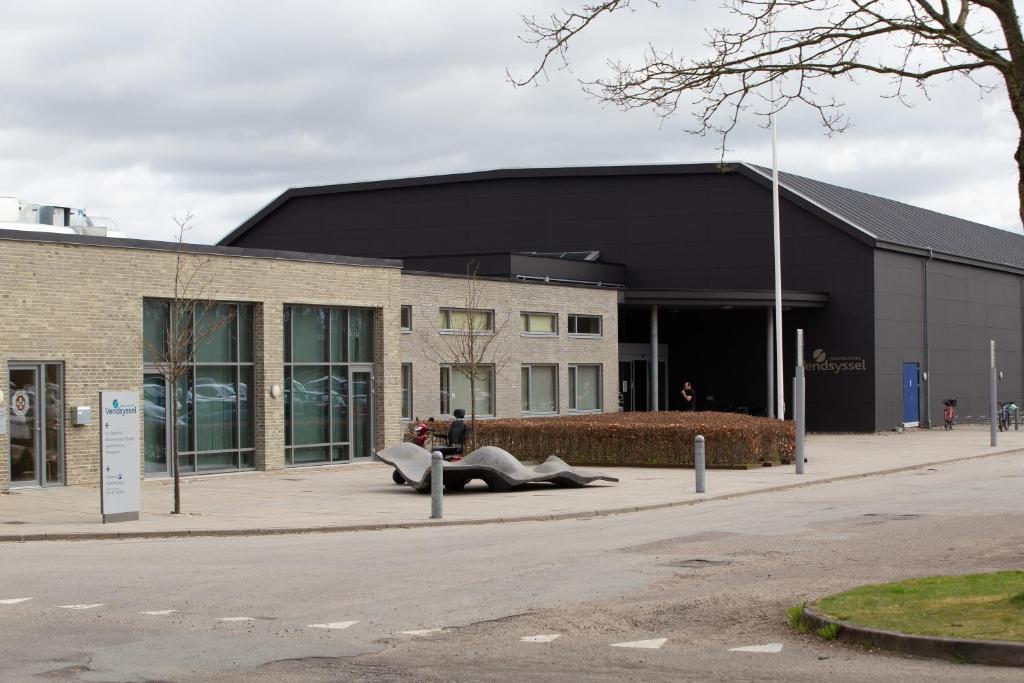un edificio con gente tirada en la acera delante de él en ICV SleepWell en Vrå