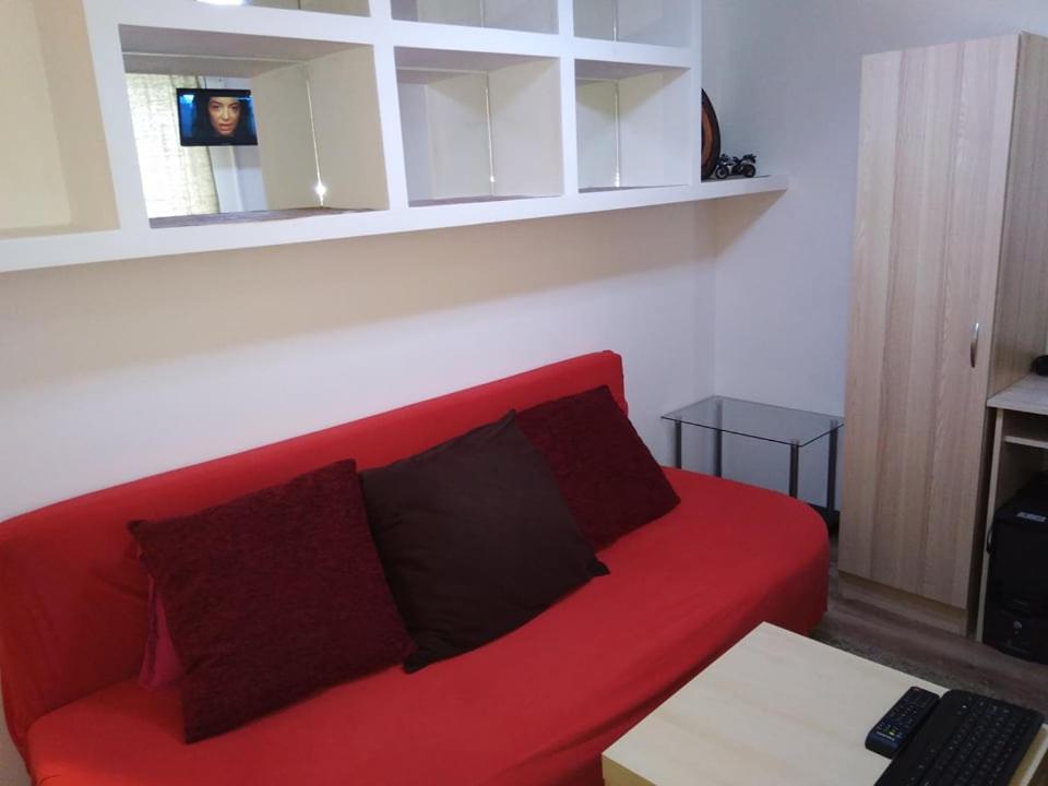 - un canapé rouge avec des oreillers dans le salon dans l'établissement Friendly House - Self Check-In, à Bucarest