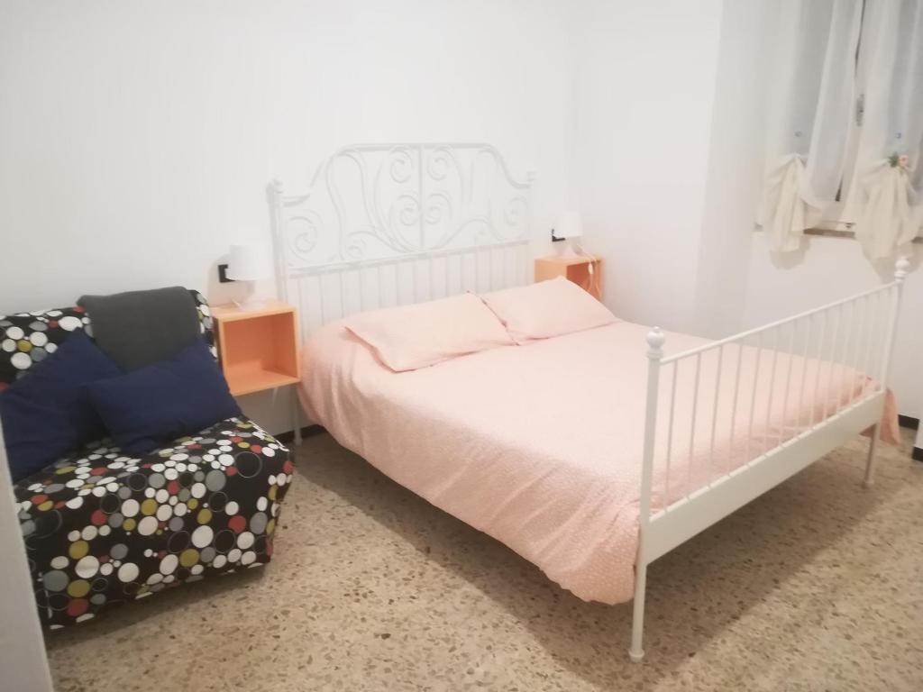 um quarto com uma cama branca e uma cadeira em Il Martello em Finale Ligure