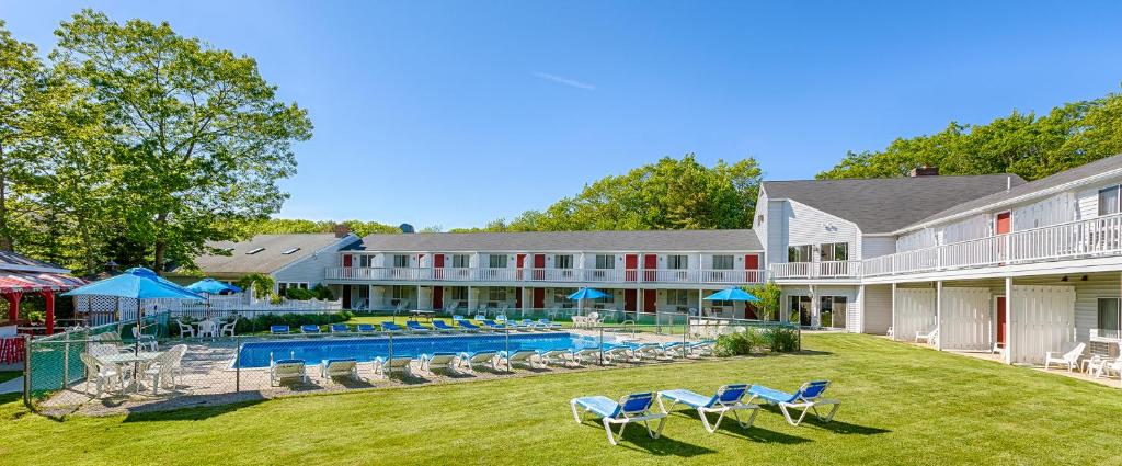 a house with lawn chairs and a pool at Rhumb Line Resort in Kennebunkport